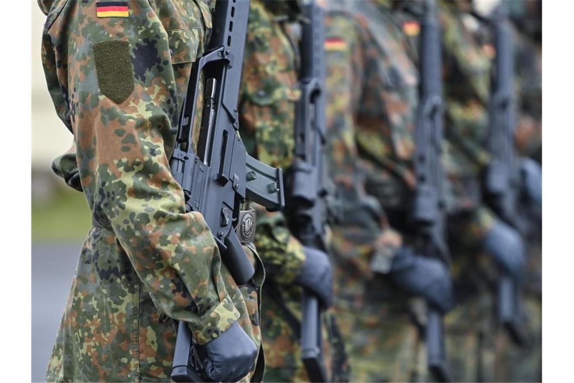 Rally bei Rüstungswerten - Ausgaben dürften steigen Soldaten vom Informationstechnikbataillon 381 der Kurmark-Kaserne tragen bei einem Apell Sturmgewehre vom Typ G36 von Heckler und Koch. Foto: Patrick Pleul/dpa-Zentralbild/dpa