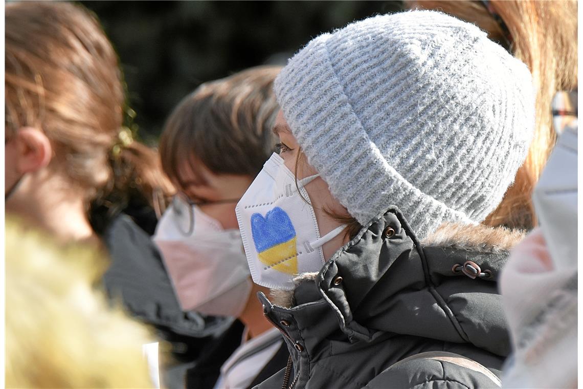 Solidaritätsbekundung in den Farben der Ukraine auf der Atemschutzmaske einer ju...