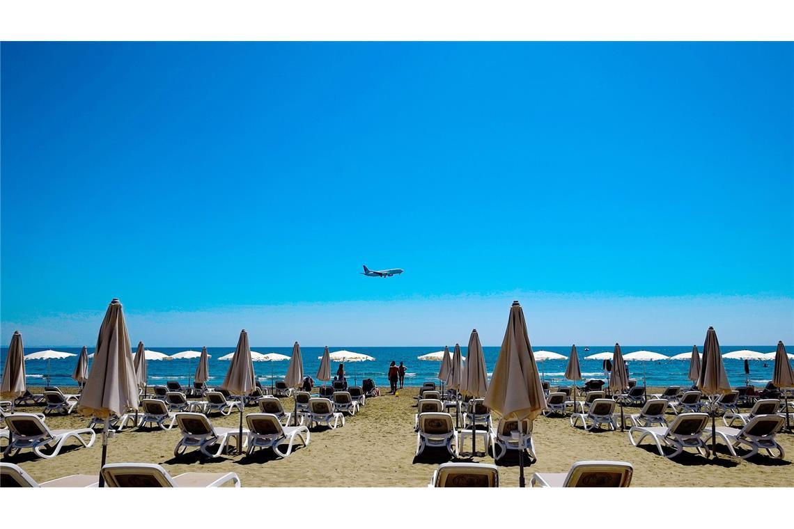 Die USA fassen Fuß auf Zypern Sonne am Strand von Larnaka in Zypern. Im Hintergrund ein Flugzeug im Anflug auf den Flughafen.