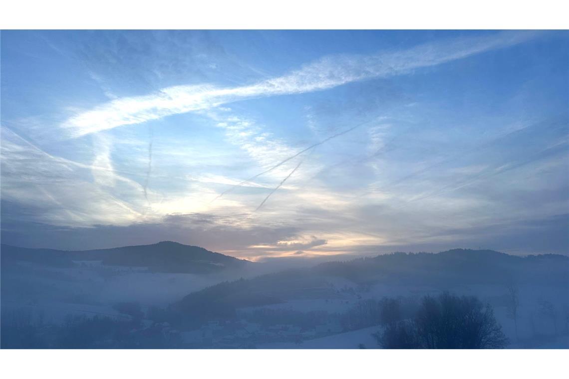 Sonne und Nebelreste sind über der winterlichen Landschaft von Obermühlbach, einem Ortsteil von Neukirchen, zu sehen.