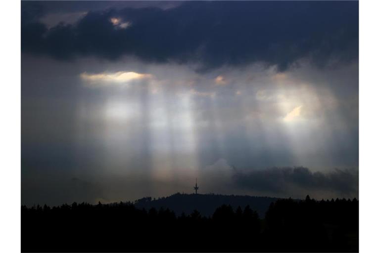 Sonnenstrahlen dringen durch Wolkenlücken. Foto: Karl-Josef Hildenbrand/dpa/Archivbild