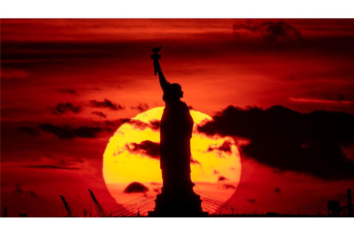 In Zeiten von Trump: Bleiben USA Traumziel für Deutsche? Sonnenuntergang hinter der Freiheitsstatue. (Archivbild)