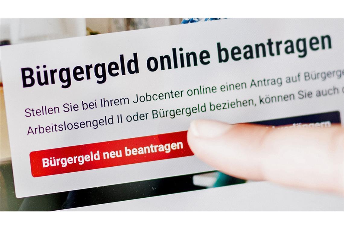 Sozialstaat – teuer, ineffizient, unbezahlbar? Eine Frau tippt auf einem Tablet auf einen Link zum Beantragen des Bürgergeldes im Kundenbereich im Jobcenter Berlin-Mitte.