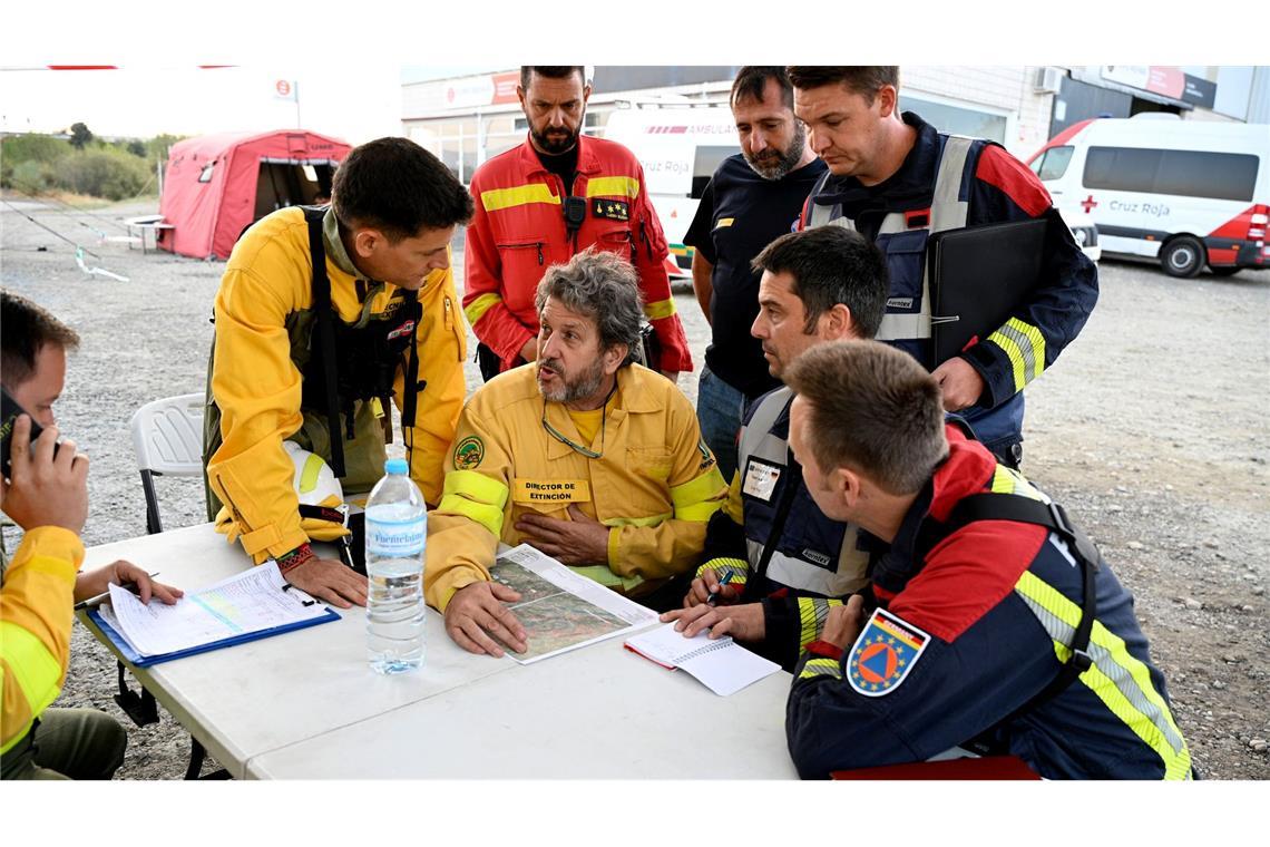 Tränen zum Abschied: Deutsche Feuerwehrleute auf Heimreise Spanische und aus Deutschland zur Hilfe geeilte Feuerwehrleute beraten bei dem Ort Jarilla über die Bekämpfung eines großen Waldbrandes. (Archivbild)