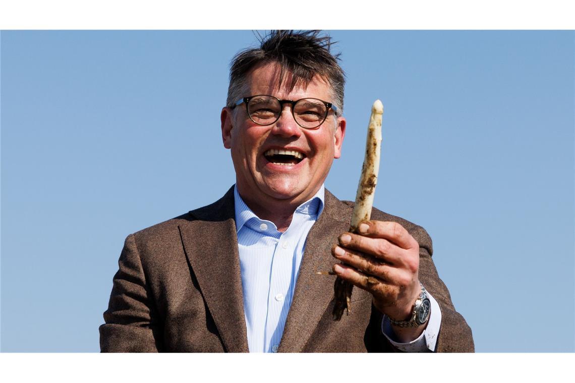 Bilder des Tages Spargelzeit in Hessen: Ministerpräsident Boris Rhein präsentiert lachend eine selbst gestochene Spargelstange.