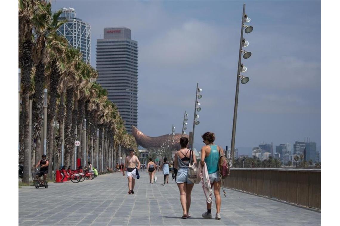 Reisewarnung für Teile Spaniens: Barcelona betroffen Spaziergänger auf der Strandpromenade in Barcelona. Foto: Thiago Prudencio/