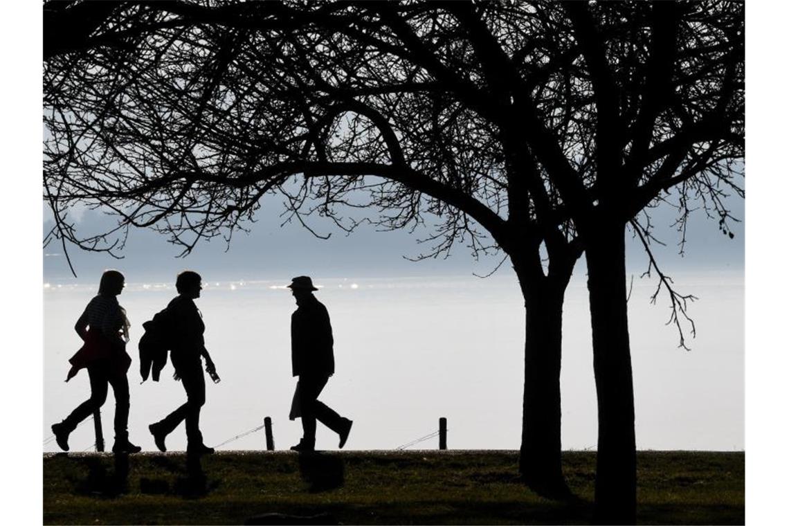 Dem Südwesten drohen Blitz und Donner Spaziergänger gehen auf einem Wanderweg am Bodensee. Foto: Felix Kästle/dpa/Archivbild
