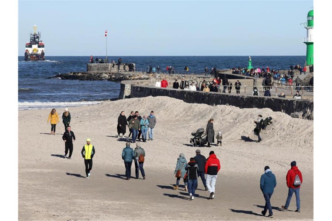 Nach Sturm und Regen ruhiges Winterwetter Spaziergänger genießen am Ostseestrand in Warnemünde das sonnige Wetter. Foto: Bernd Wüstneck/dpa-Zentralbild/dpa