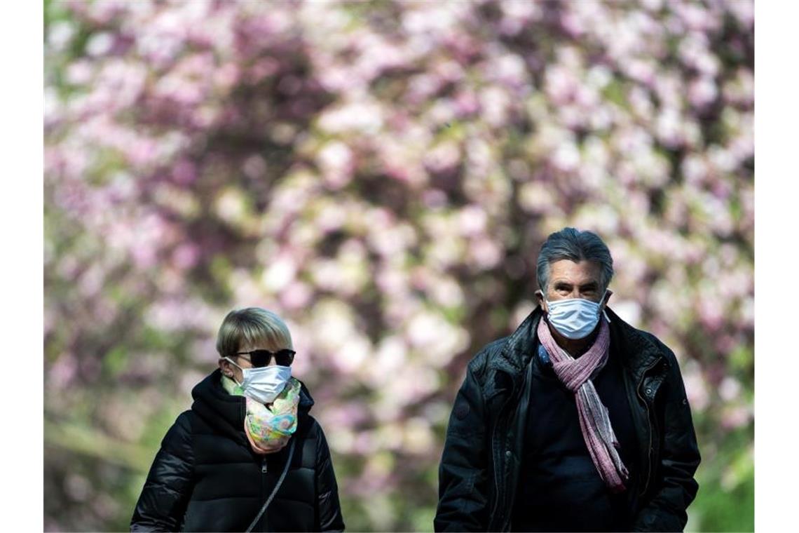 Spaziergänger mit Mundschutz in Köln. Foto: Federico Gambarini/dpa