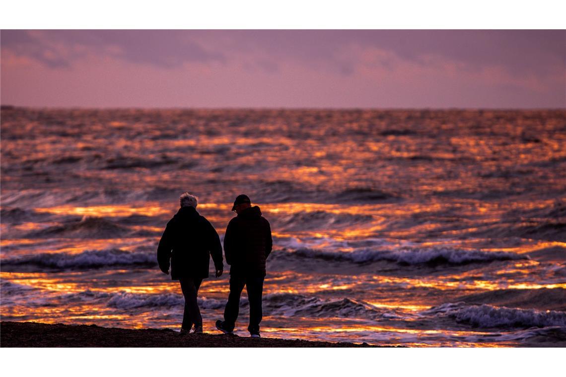 Bilder des Tages Spaziergänger sind nach Sonnenuntergang am Strand von Warnemünde an der Ostsee unterwegs.