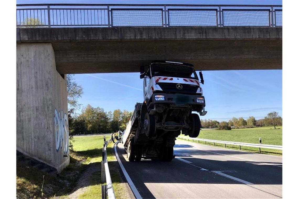 80-Jähriger bleibt mit Lkw spektakulär an Brücke hängen Spektakulärer Lkw-Unfall eines 80-Jährigen in Oberbayern. Foto: Hermann Spanner/Feuerwehr Bichl/dpa