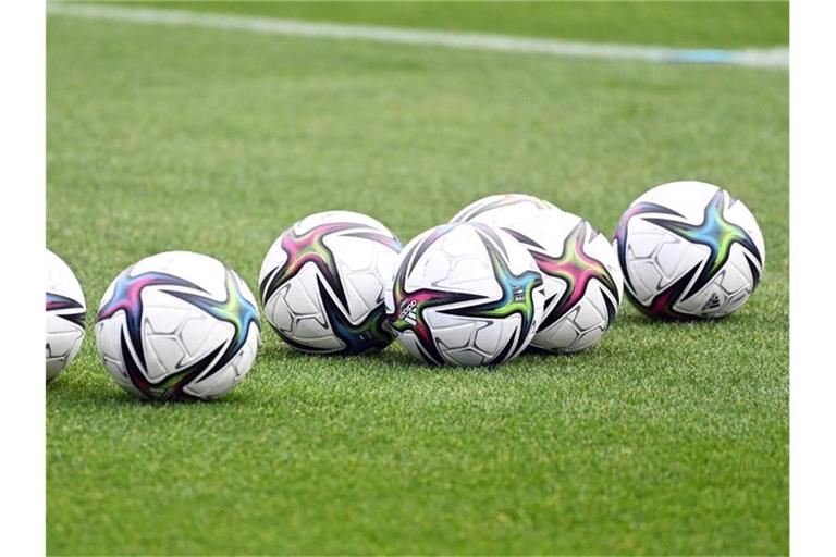 Spielbälle liegen auf dem Rasen. Foto: Swen Pförtner/dpa/Symbolbild