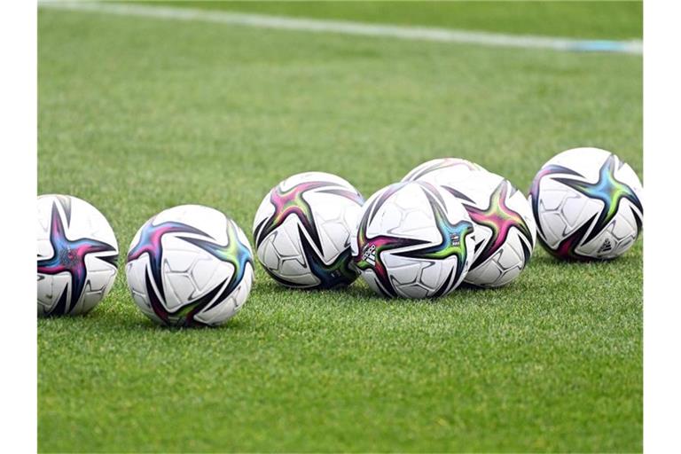 Spielbälle liegen auf dem Rasen. Foto: Swen Pförtner/dpa/Symbolbild