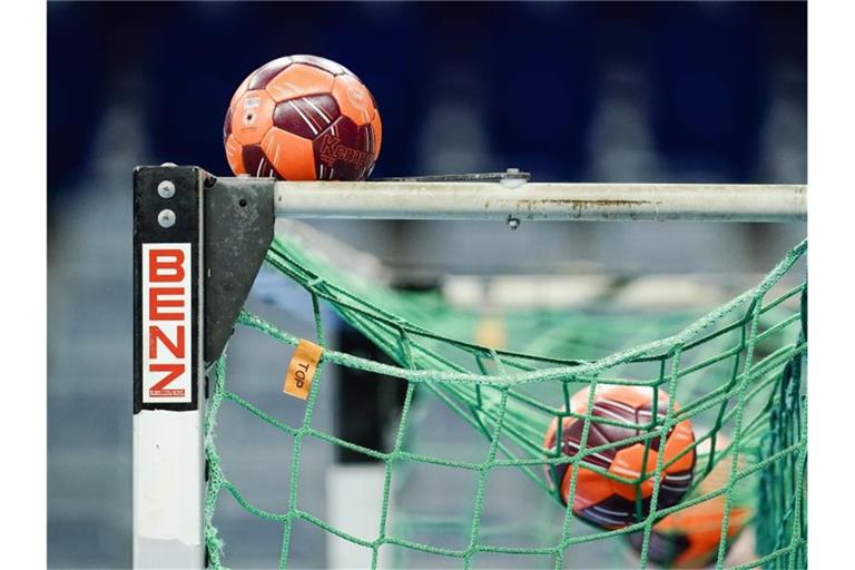 Spielbälle liegen im Netz eines Handball-Tors. Foto: Uwe Anspach/dpa/Symbolbild