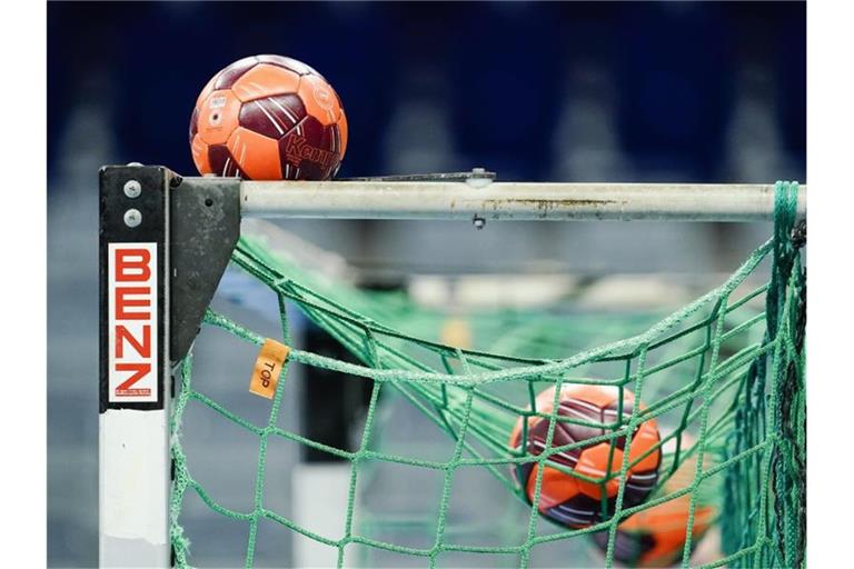 Spielbälle liegen im Netz eines Handball-Tors. Foto: Uwe Anspach/dpa/Symbolbild