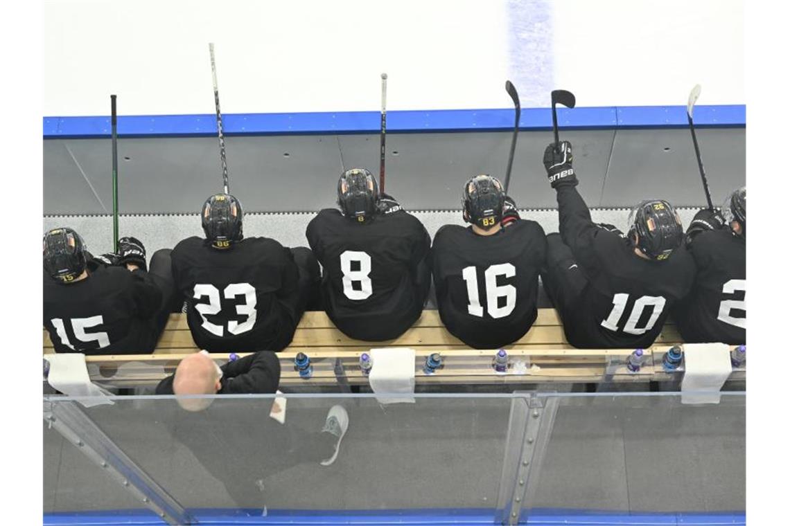 DEB-Team startet neue Mission Gold: Auftakt als Favorit Spieler der deutschen Eishockey-Nationalmannschaft sitzen bei einer Trainingseinheit auf der Bank. Foto: Peter Kneffel/dpa
