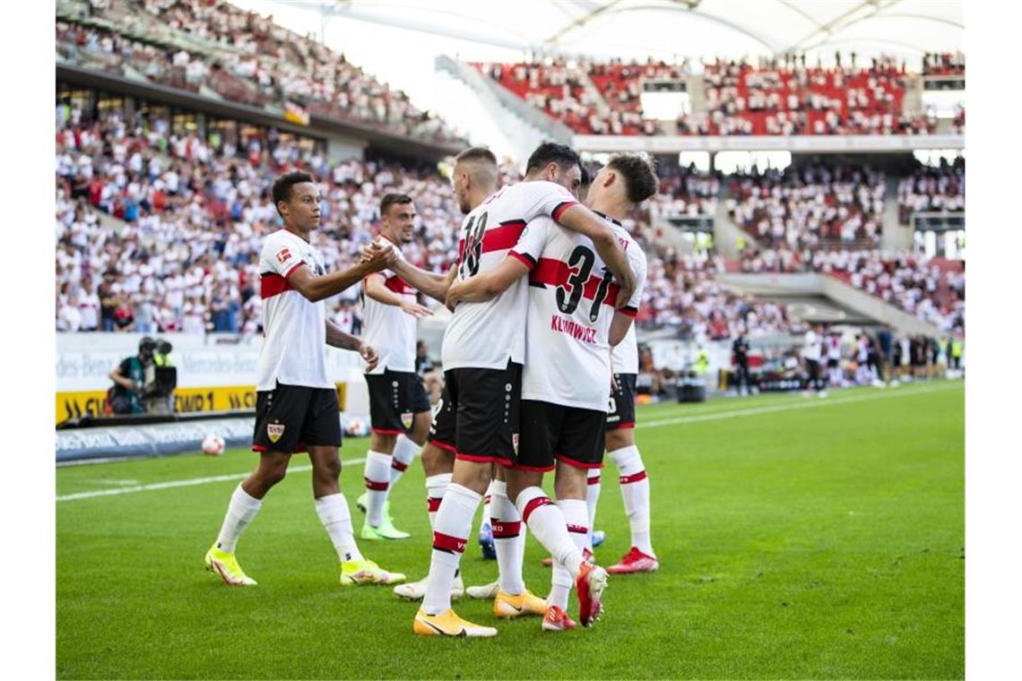 VfB-Profis Kalajdzic und Coulibaly trainieren wieder Spieler der Mannschaft umarmen sich auf dem Feld. Foto: Tom Weller/dpa/Archivbild