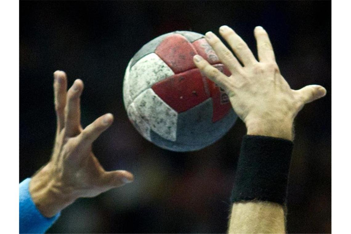 Spieler kämpfen während eines Handballspiels um den Ball. Foto: Jens Wolf/dpa-Zentralbild/dpa/Symbolbild