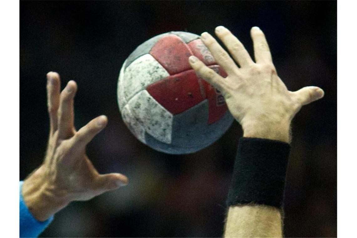 Spieler versuchen beim Handball an den Ball zu kommen. Foto: Jens Wolf/dpa-Zentralbild/dpa/Archivbild