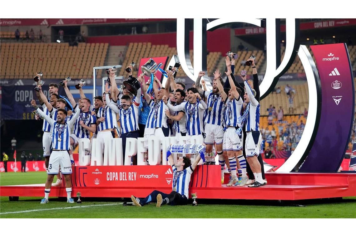 Spieler von Real Sociedad feiern mit dem Pokal.