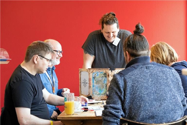 Spielleiter Achim Bechthold (Mitte) hat für das Treffen ein selbstentworfenes Spiel mitgebracht. Convention-Initiator Dirk Jerusalem (Zweiter von links) gesellt sich als Spieler zur Runde. Fotos: Alexander Becher