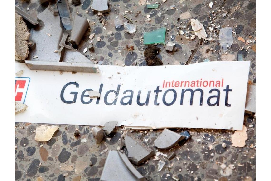 Splitter und ein abgerissenes Schild auf dem Fußboden vor einem gesprengten Geldautomaten. Foto: Patrick Pleul/dpa-Zentralbild/dpa