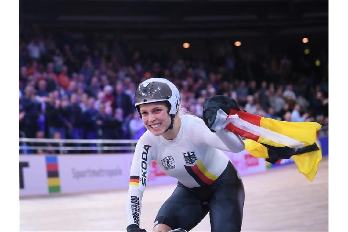 Sprintsiegerin Emma Hinze dreht mit einer deutschen Fahne eine Ehrenrunde. Foto: Sebastian Gollnow/dpa