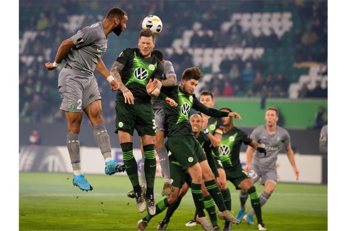 Großer Gegner droht: VfL Wolfsburg verpasst Gruppensieg St. Etiennes Harold Moukoudi (l) ist vor VfL-Profi Daniel Ginczek am Ball. Foto: Swen Pförtner/dpa