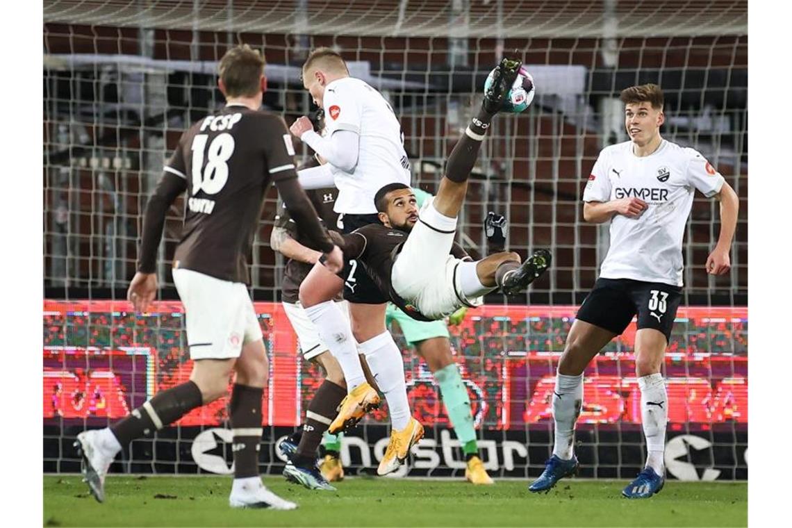 FC St. Pauli gewinnt auch gegen Sandhausen St. Paulis Daniel-Kofi Kyereh (M) scheitert mit einem Fallrückzieher. Foto: Christian Charisius/dpa/Pool/dpa