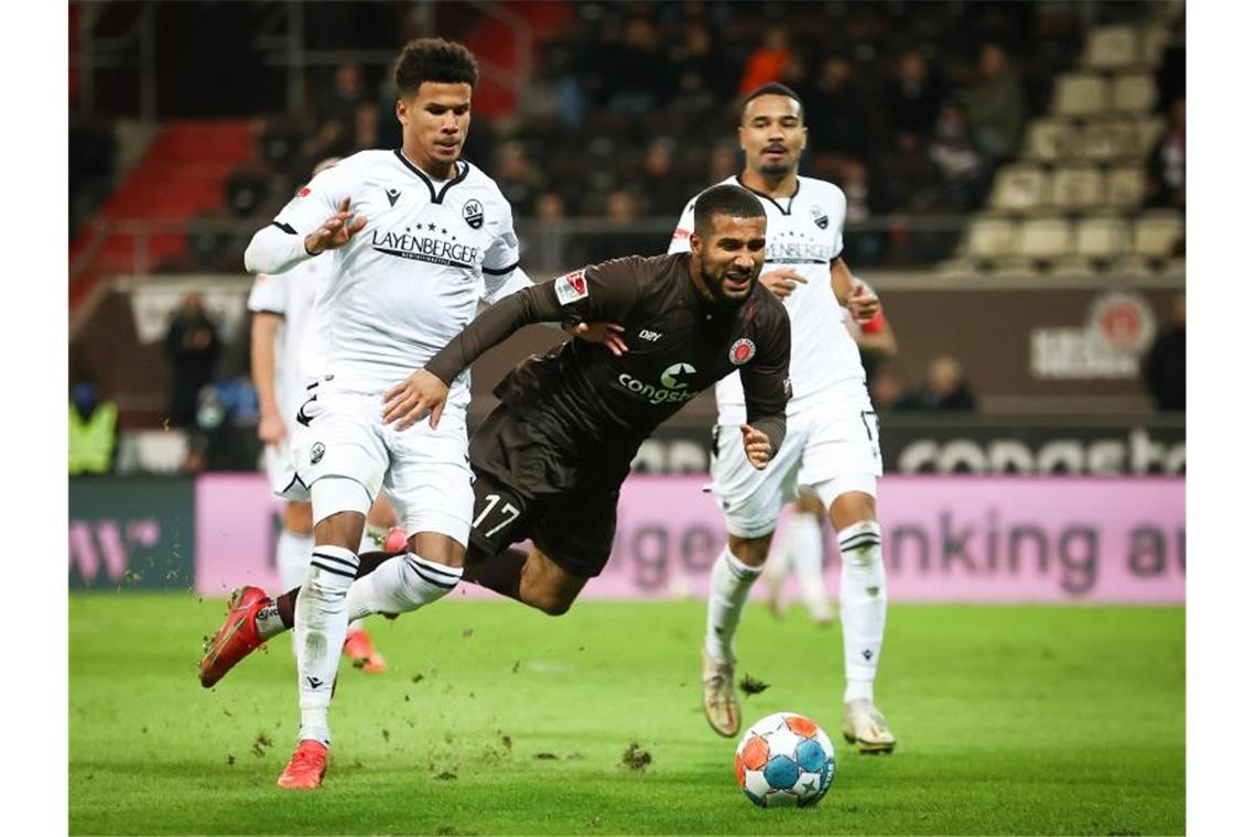 Sieg über Sandhausen: FC St. Pauli zurück an Tabellenspitze St. Paulis Daniel-Kofi Kyereh (M) und Sandhausens Chima Okoroji (l) im Kampf um den Ball. Foto: Christian Charisius/dpa