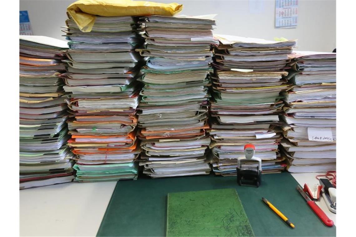 Stapel mit Akten liegen auf einem Schreibtisch. Laut einer Umfrage sind die Corona-Hilfen der Bundesregierung für den Mittelstand oft zu bürokratisch. Foto: Stephanie Pilick/dpa