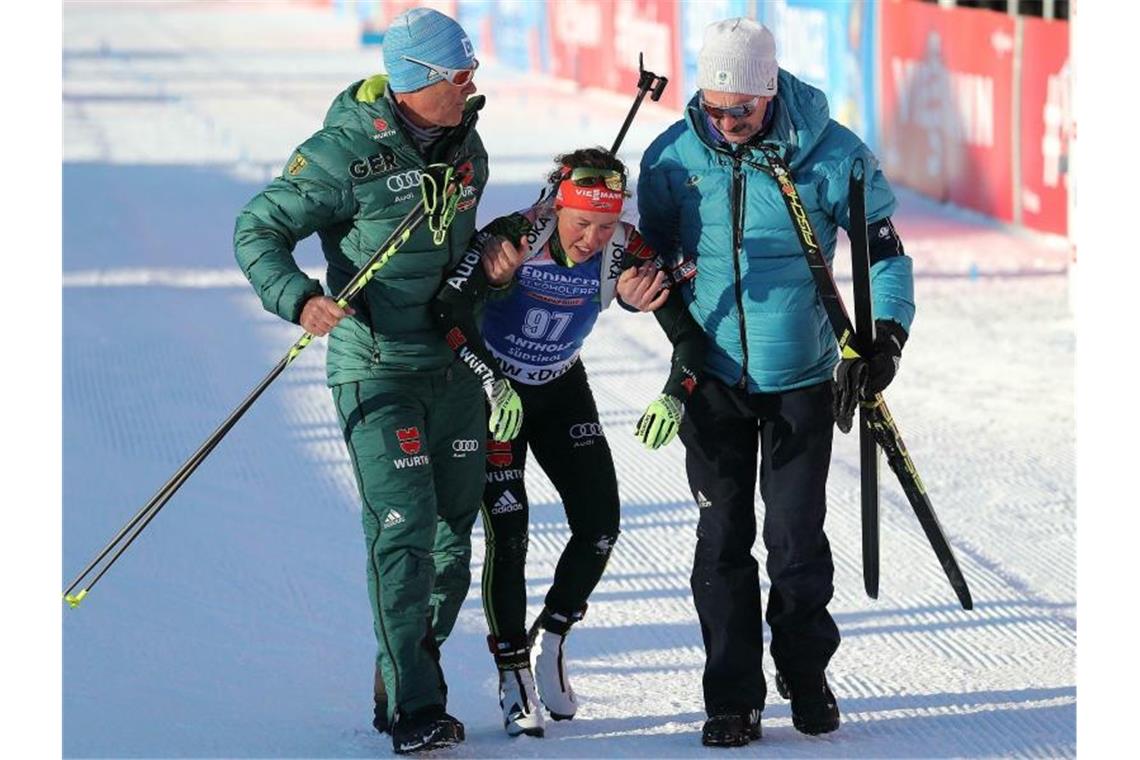Stark am Rande ihrer Kräfte ist Laura Dahlmeier beim Sprint als Vierte ins Ziel gelaufen. Helfer müssen sie nach dem Rennen stützen. Foto: Andrea Solero/ANSA