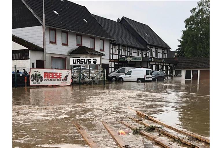 Starkregen hat eine Straße im niedersächsischen Bad Gandersheim überflutet. Foto: Konstantin Mennecke/dpa