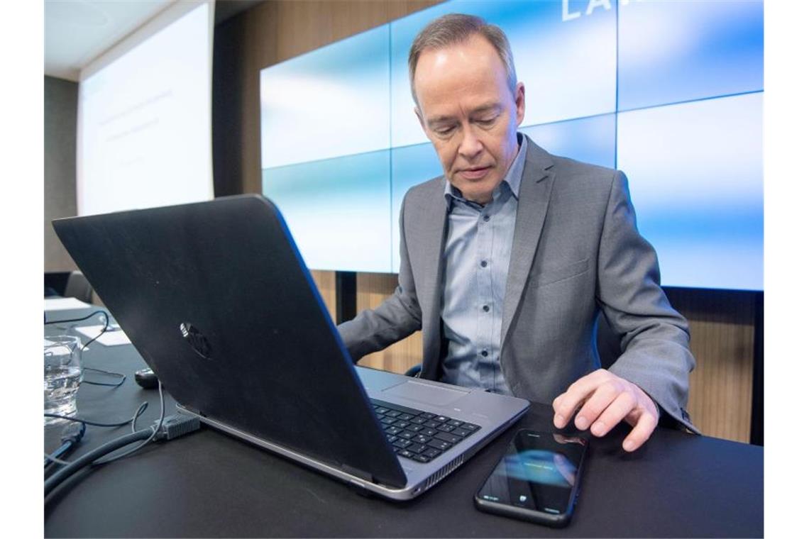 Stefan Brink bedient vor einer Pressekonferenz sein Smartphone. Foto: Marijan Murat/dpa/Archivbild