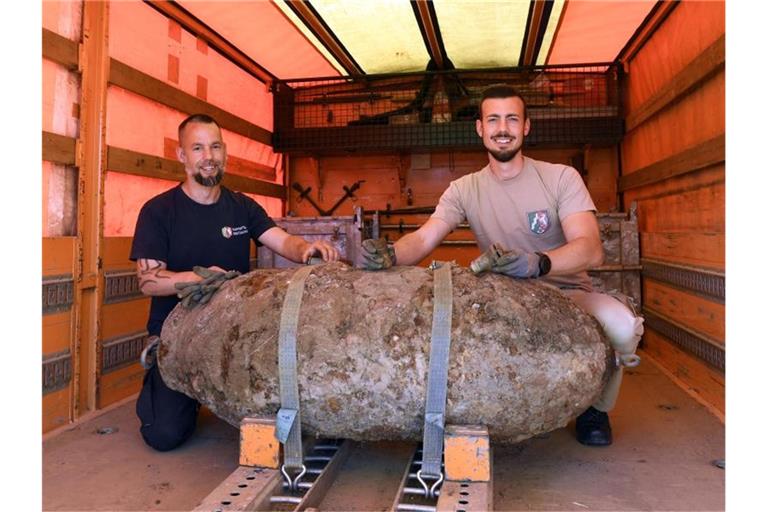 Stefan Höreth (r) und Christoph Wassenberg vom Kampfmittelbeseitigungsdienst mit der entschärften Zehn-Zentner-Weltkriegsbombe. Foto: Roberto Pfeil/dpa