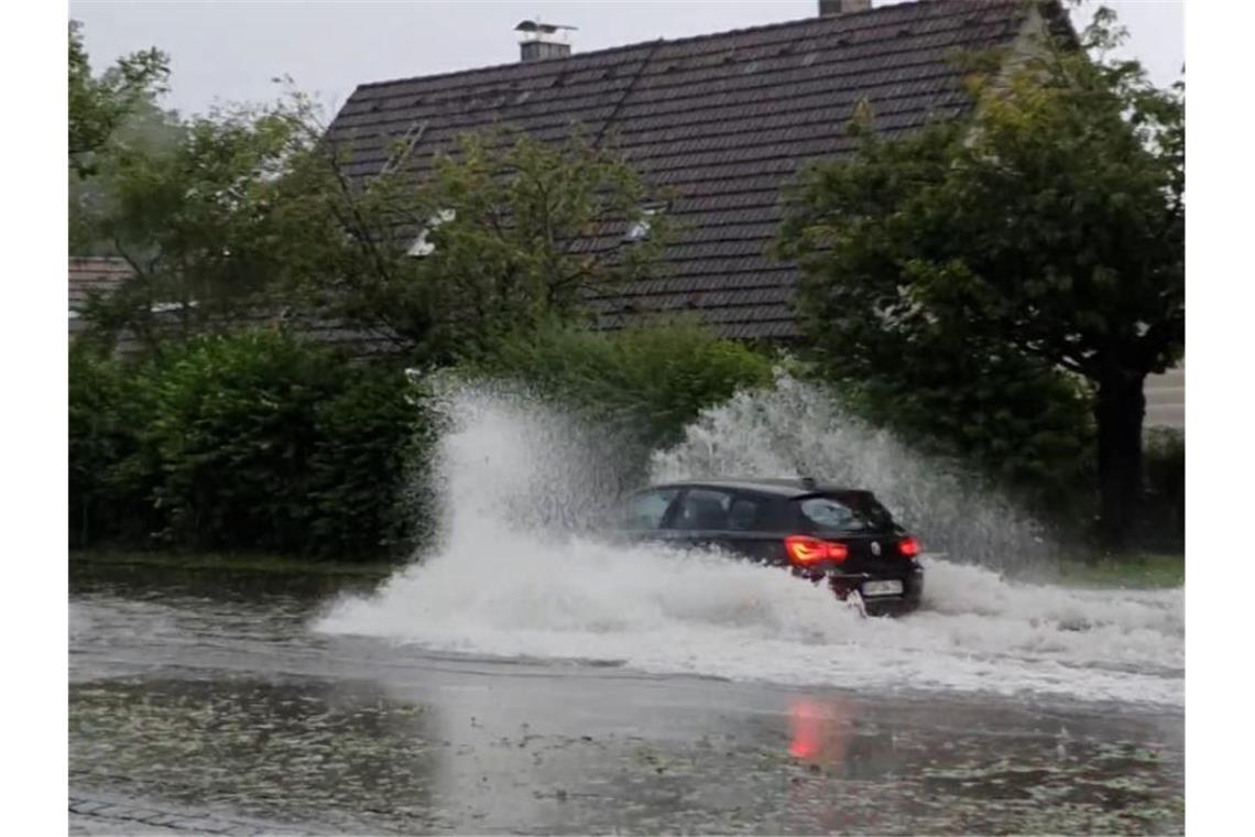 Kräftige Unwetter in einigen Regionen Deutschlands Stehendes Wasser auf einer Straße im bayerischen Penzberg. Foto: Vifogra/dpa