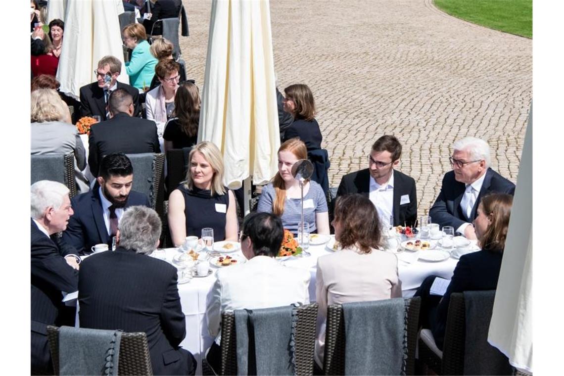 Steinmeier ruft Bürger am Verfassungstag zum Einmischen auf Steinmeier (r) unterhält sich bei der Geburtstagskaffeetafel im Park vom Schloss Bellevue mit geladenen Gästen. Foto: Bernd von Jutrczenka