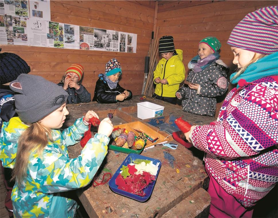 Sterne aus Wachs werden von den Kindern im Außenbereich des Waldheim-Kindergartens aufgefädelt. Das macht Spaß und ist Anlass, zu Hause über das Erlebte zu sprechen. So kommt das Thema Weihnachten auch in nicht christliche Familien. Foto: A. Becher