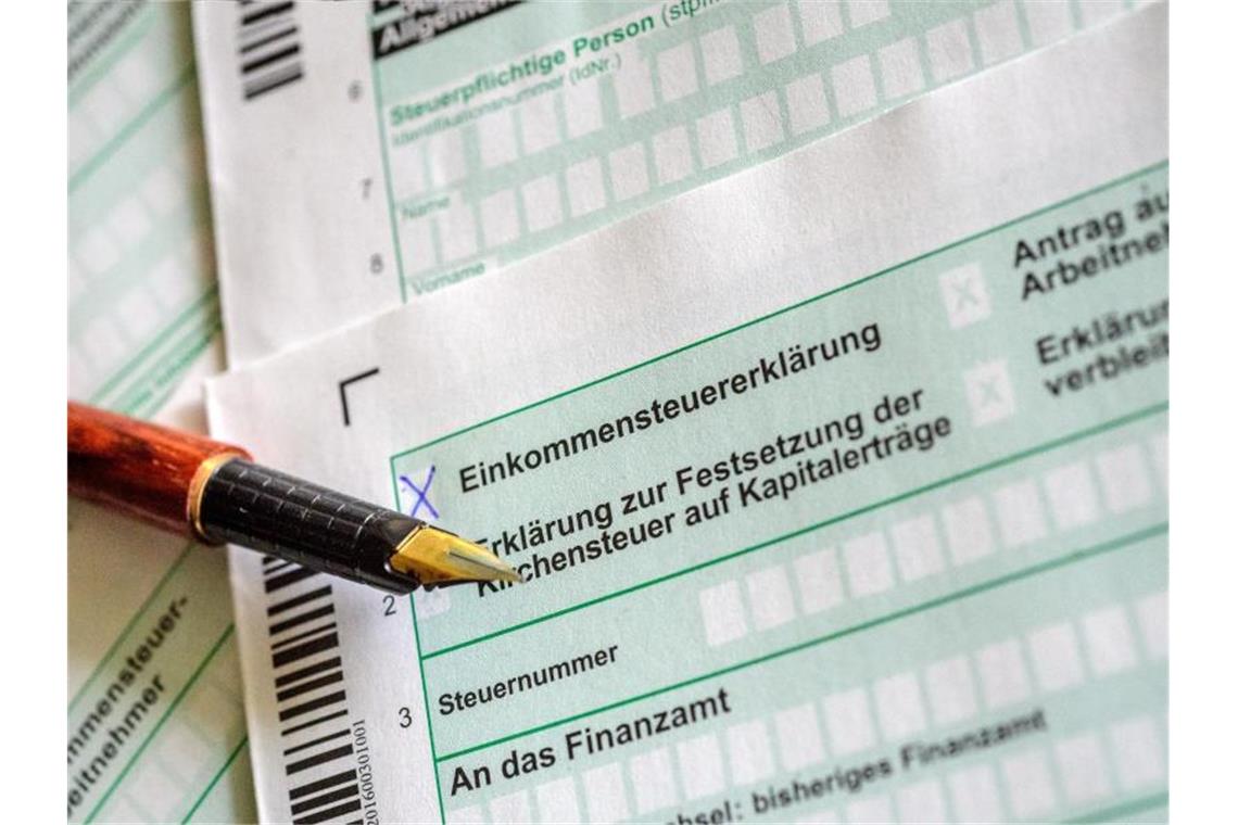 Steuerformulare und Füllfederhalter liegen auf einem Tisch. Foto: Hans-Jürgen Wiedl/dpa-Zentralbild/dpa/Illustration
