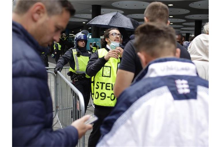 Stewards kontrollieren die elektronischen Tickets der Fans beim Betreten des Wembley-Stadions. Foto: David Cliff/AP/dpa