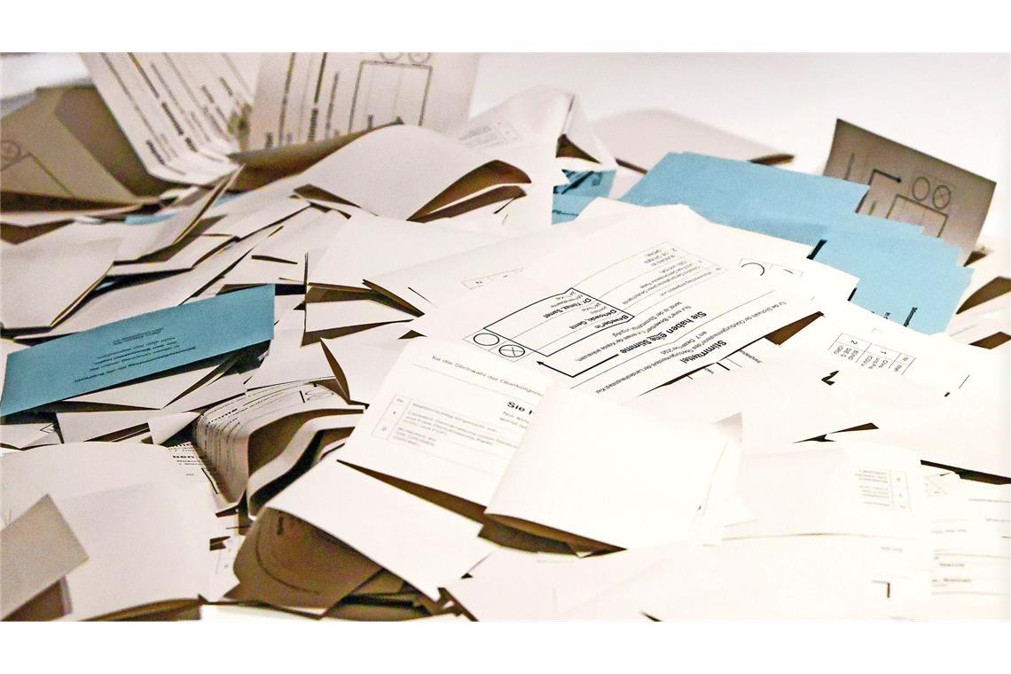 Stimmzettel liegen auf einem Tisch in einem Wahllokal.