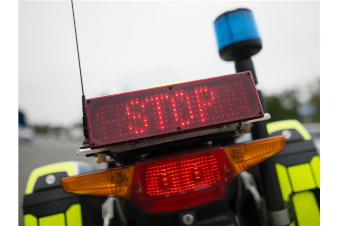 "Stop" steht auf einer Anzeige eines Polizeimotorrads. Foto: picture alliance/dpa/Symbolbild