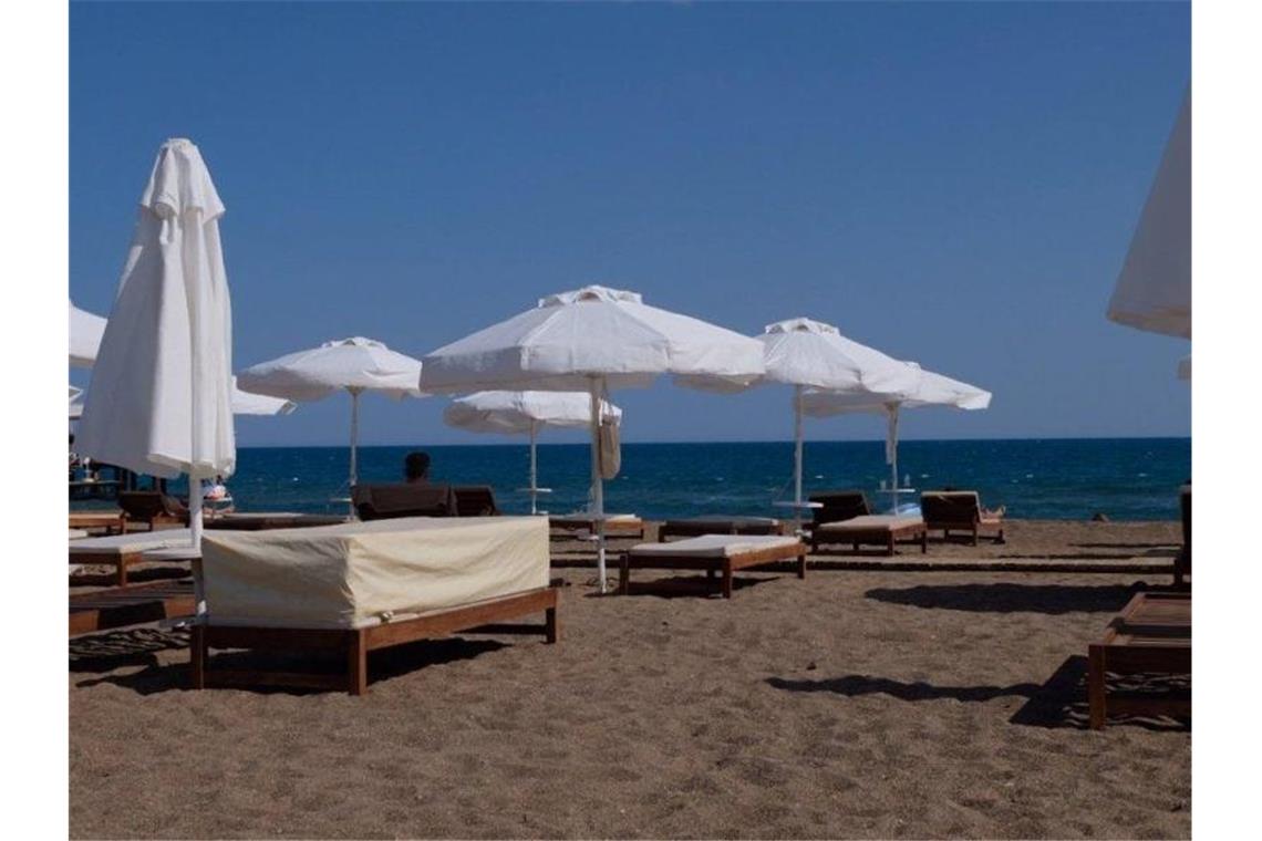 Türkei-Tourismus: Minister warnt vor „unnötiger Polemik“ Strandliegen und Sonnenschirme am menschenleeren Strand in Antalya (Archivfoto). Foto: Mirjam Schmitt/dpa