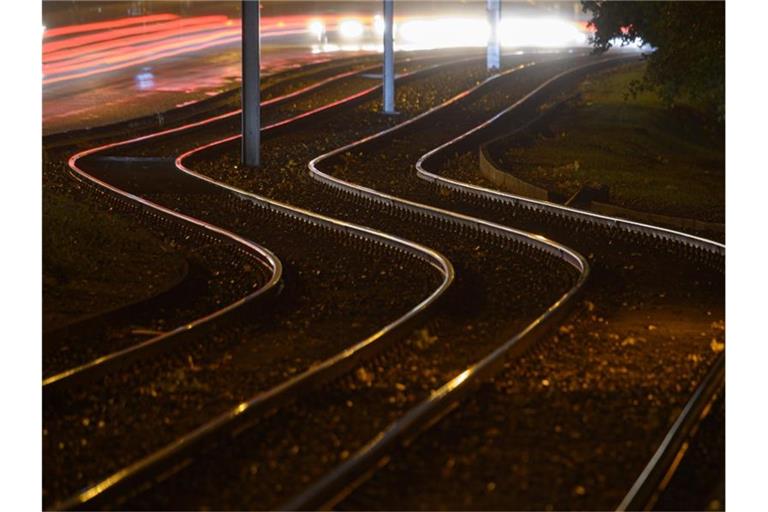 Straßenbahngleise werden von Straßenlaternen beleuchtet. Foto: Robert Michael/dpa-Zentralbild/dpa/Symbolbild