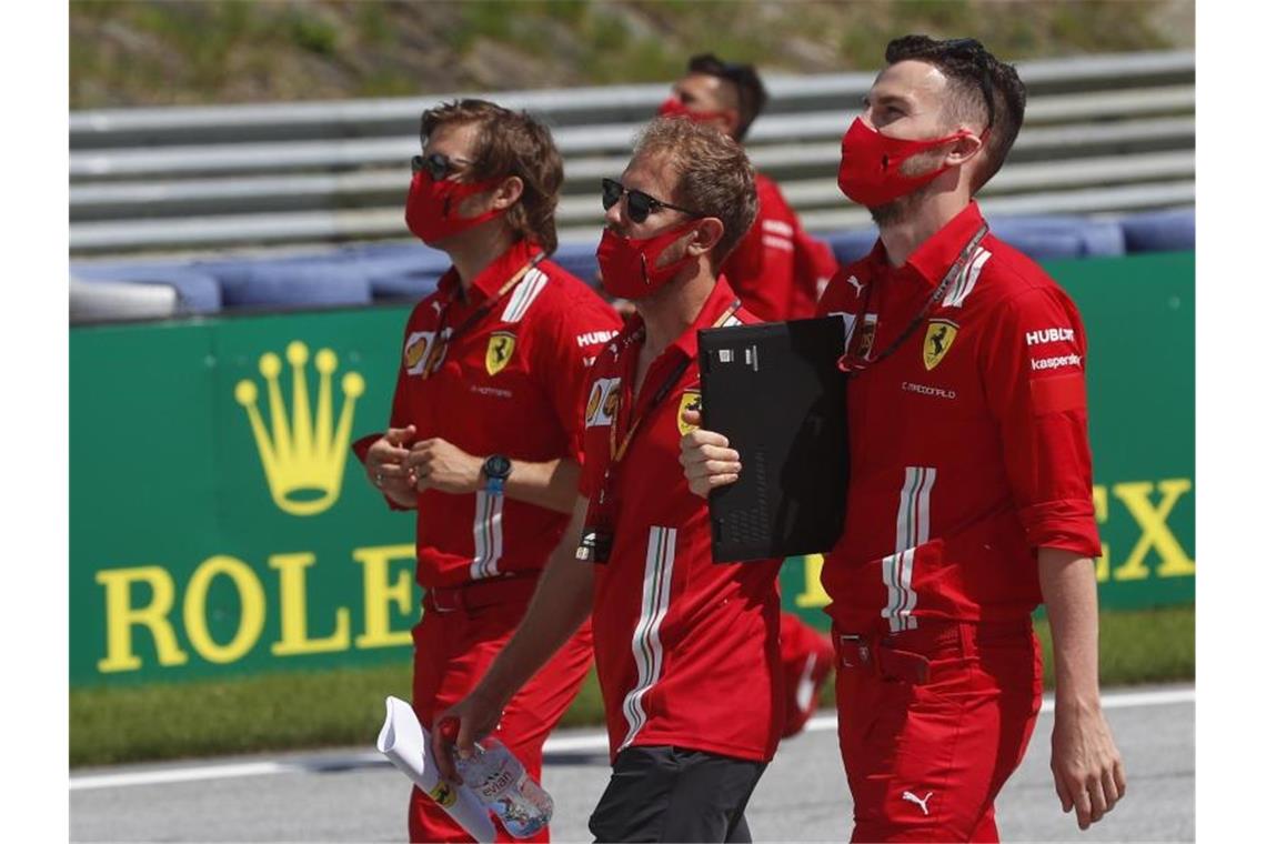Rennen ins Ungewisse: Formel 1 startet die Corona-Saison Streckenbesichtigung: Sebastian Vettel (M) und seine Kollegen starten in Spielberg in die Saison. Foto: Darko Bandic/AP/dpa