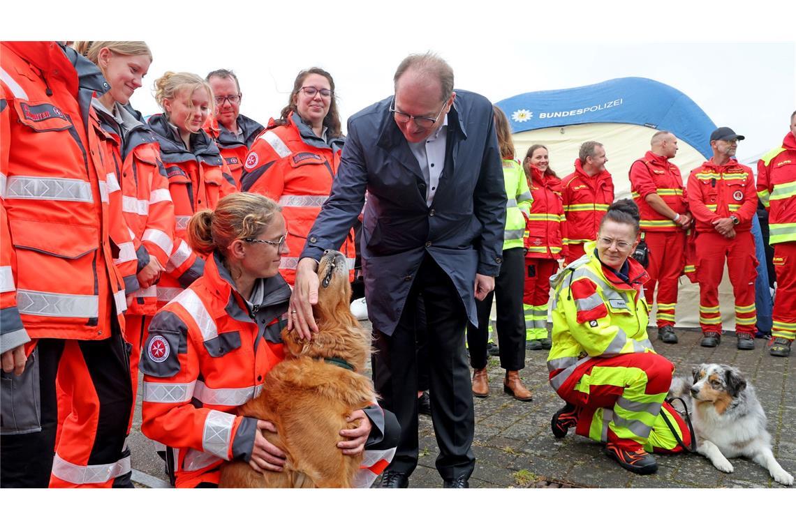 Bilder des Tages Streicheleinheiten für den vierbeinigen Helfer von Bundesinnenminister Alexander Dobrindt, der die Rettungshundestaffel beim bundesweiten Bevölkerungsschutztag im Stadthafen von Rostock besucht.