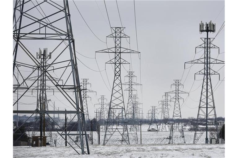 Strommasten stehen auf mit Schnee bedeckten Feldern beu Fort Worth im Bundesstaat Texas. Foto: Ralph Lauer/ZUMA Wire/dpa