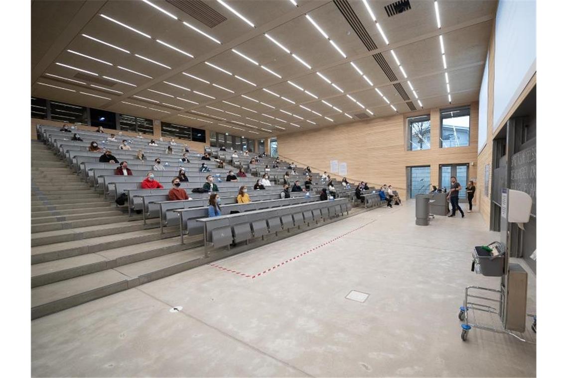 Im Corona-Semester: Kaum Vorlesungen an Unis ausgefallen Studierende mit Mund- und Nasenmaske sitzen in der Begrüßungsveranstaltung für Studierende im ersten Semester an der Universität Hohenheim. Foto: Sebastian Gollnow/dpa
