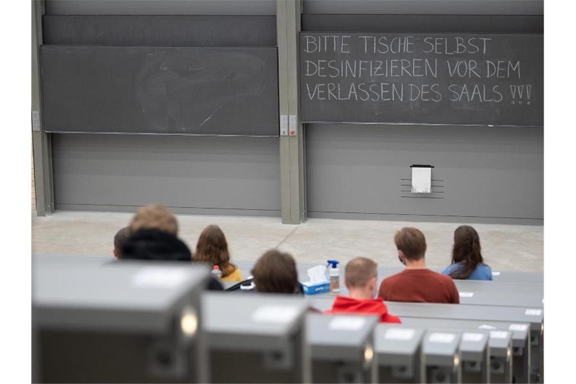 Ungeimpfte Studierende dürfen ab Montag getestet zur Uni Studierende mit Mund- und Nasenmaske sitzen in einem Hörsaal. Foto: Sebastian Gollnow/dpa/Symbolbild