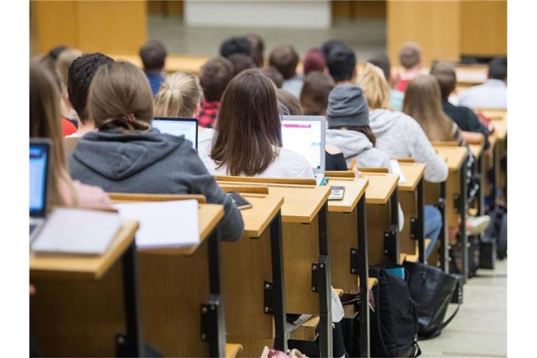 Studierende sitzen mit Laptops an der Universität in einer Vorlesung. Foto: Sebastian Gollnow/dpa